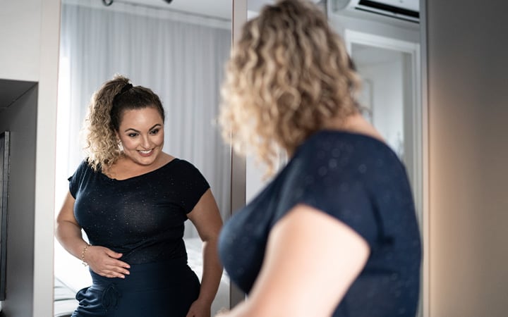 Woman smiling at herself in the mirror