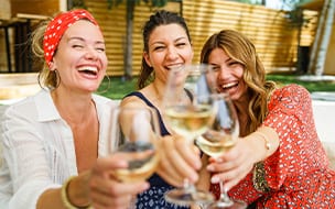 Three women drinking white wine on a sunny day