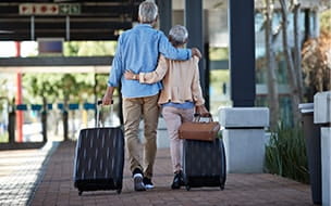 Couple walking with luggage at airport