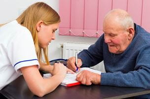 Elderly man signing medical papers at the doctor's office
