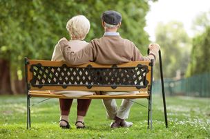 Older couple relaxing on park bench