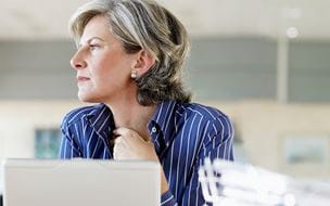 Woman looking out the window in front of her computer