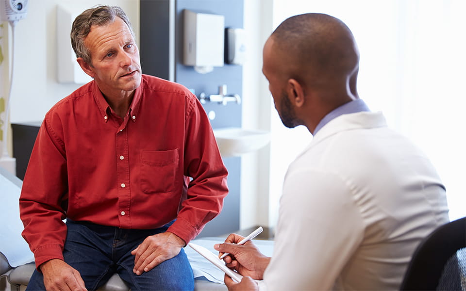 Male patient and doctor in hospital room offer consultation
