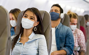 Woman traveling by plane wearing a facemask