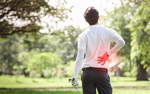 Man holding his back from a sport injury playing golf