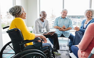 Senior woman in a wheelchair talking in a group setting