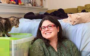 Woman with Asperger syndrome playing with her pet cats