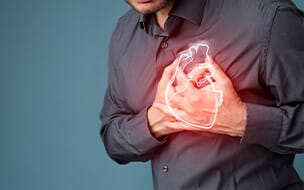 Man grabbing grabbing his chest over his heart