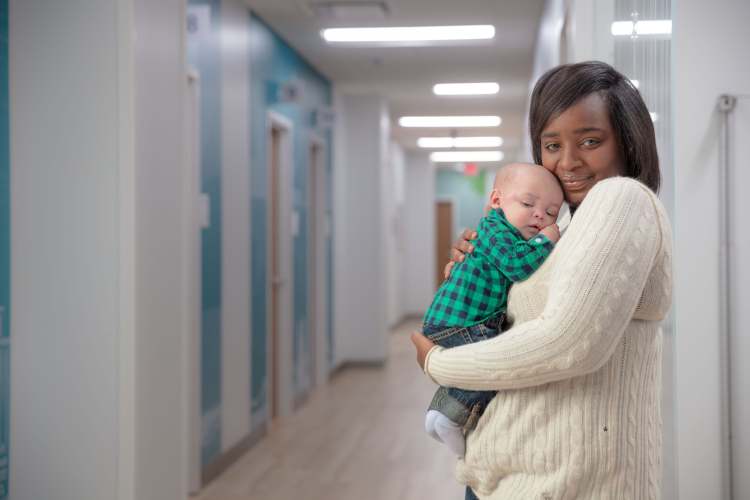 woman holding baby in hospital hall