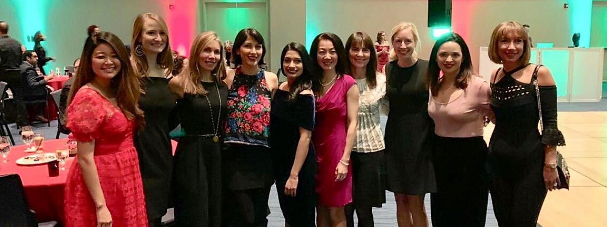 Row of standing women and smiling at annual department holiday party