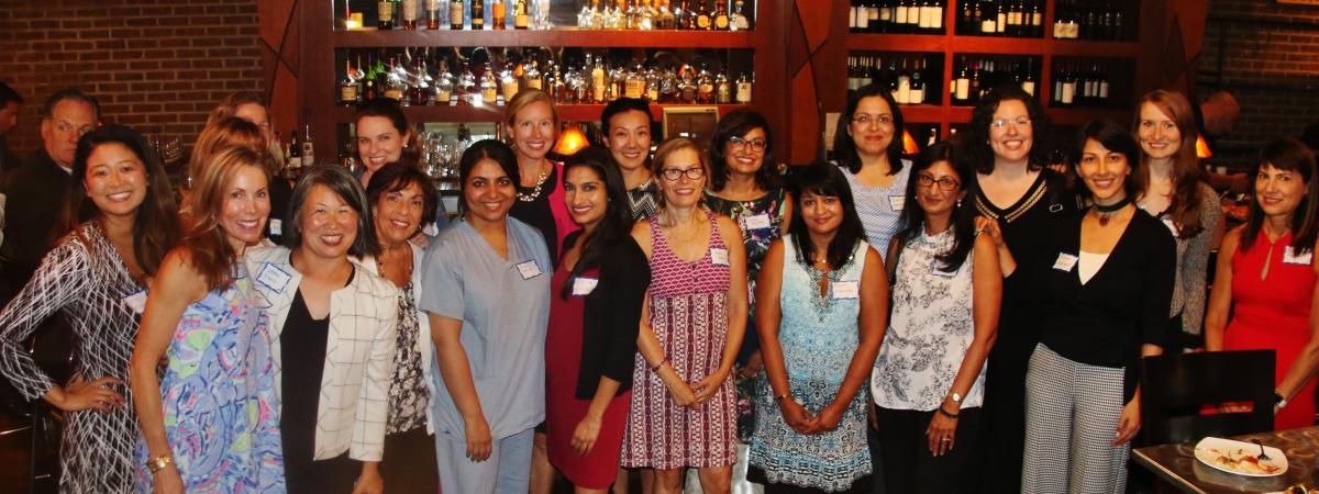 Group photo of women in radiology standing in front of bar at restaurant
