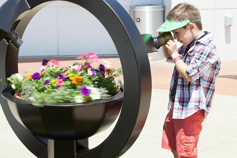 A boy using the microscope planter in Angies' Garden at Rainbow Babies & Children’s Hospital