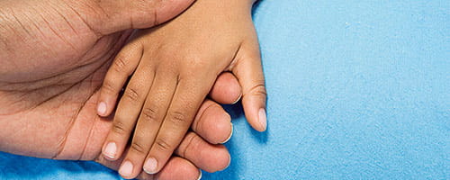 A boy holding his parent's hand