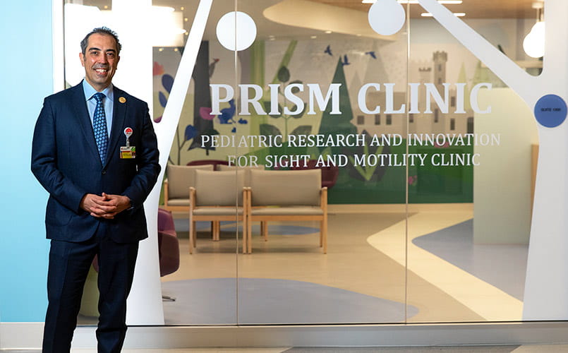 Faruk H. Örge MD, FAAO, FAAP stands at the entrance to the PRISM Clinic