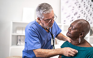 Doctor using a stethoscope listen to the heartbeat of the elderly patient