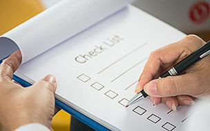 Closeup of person completing checklist on clipboard