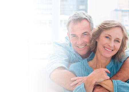 A content man hugging his wife on the couch