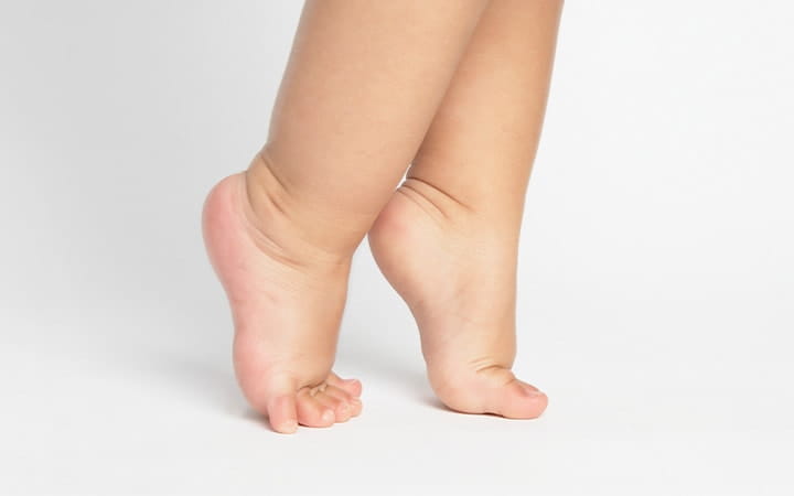 Baby girl walking on tiptoe