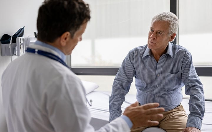 A doctor talking to a senior patient in a consultation at the office