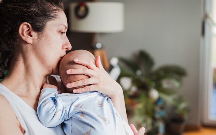 Mom kisses baby