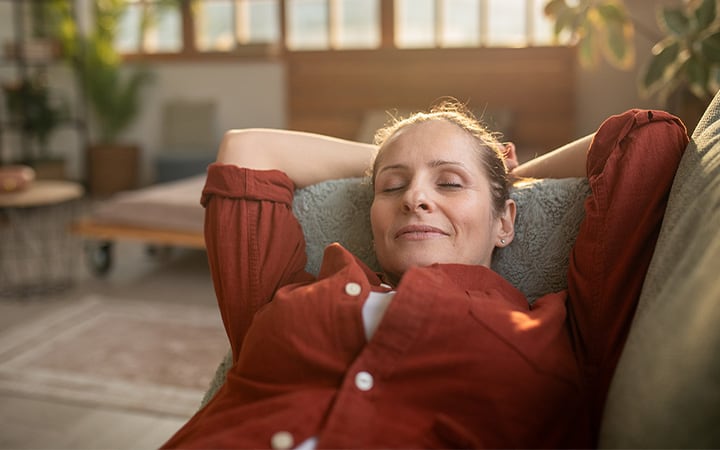A middle aged woman relaxing in the living room of her apartment