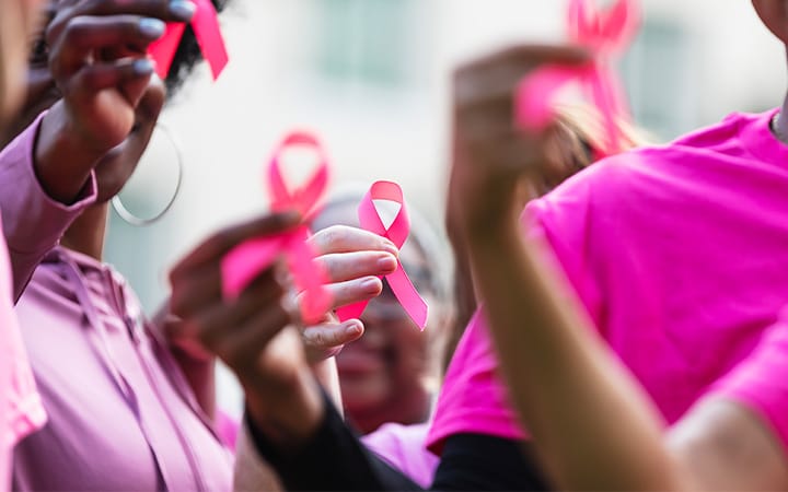 Cropped view of a multiracial group of women dressed in pink attending a breast cancer awareness event