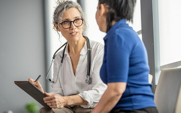 A medical practitioner discussing healthcare concerns with her patient in a modern clinic environment