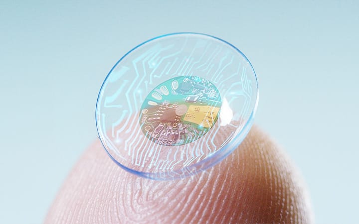 Closeup of a finger holding a high-tech contact lens