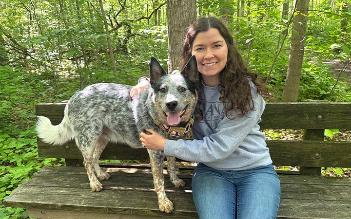 Hip dysplasia patient Jena sits on a park bench with her dog