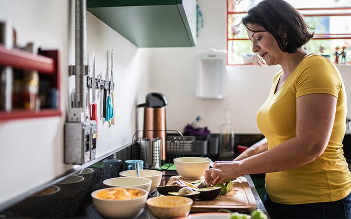 woman slicing avocados in kitchen