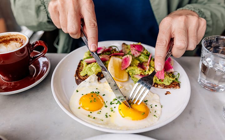 avocado toast and sunny-side up eggs on plate