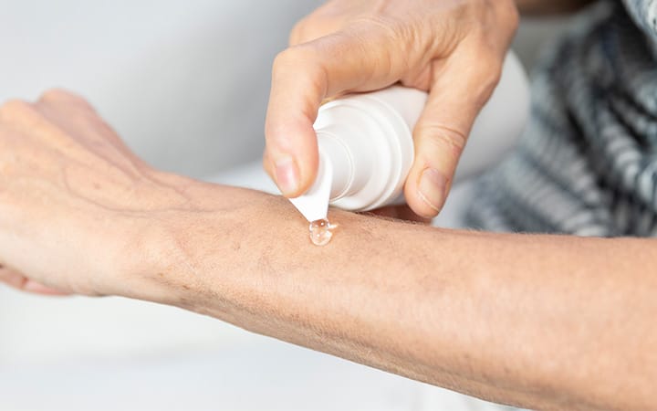 A woman applying post-menopause hormone gel