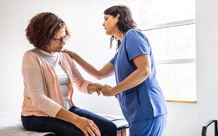 A nurse giving a senior woman a joint exam