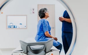 A senior woman talking to a nurse on a MRI tomography at a health center