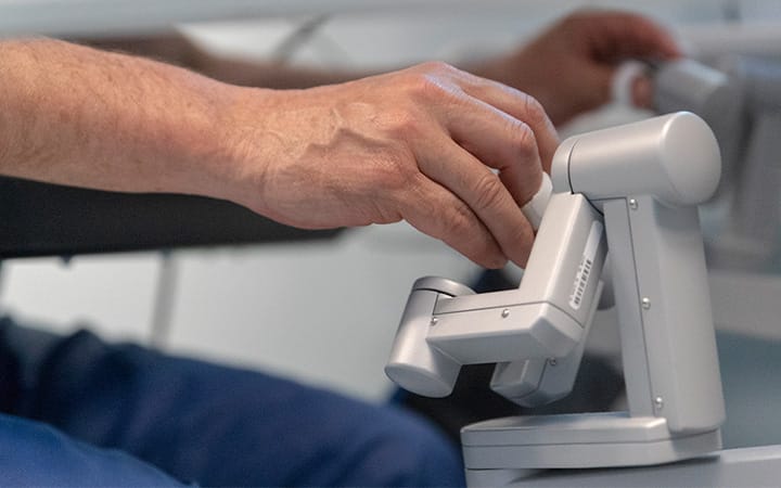 A surgeon manipulates the controls of a robot that operates a patient