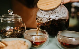 Teapot pouring tea into a teacup