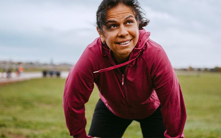 A mature woman rests while exercising in a park