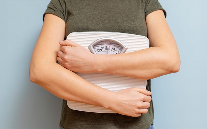 a person holding a bathroom scale