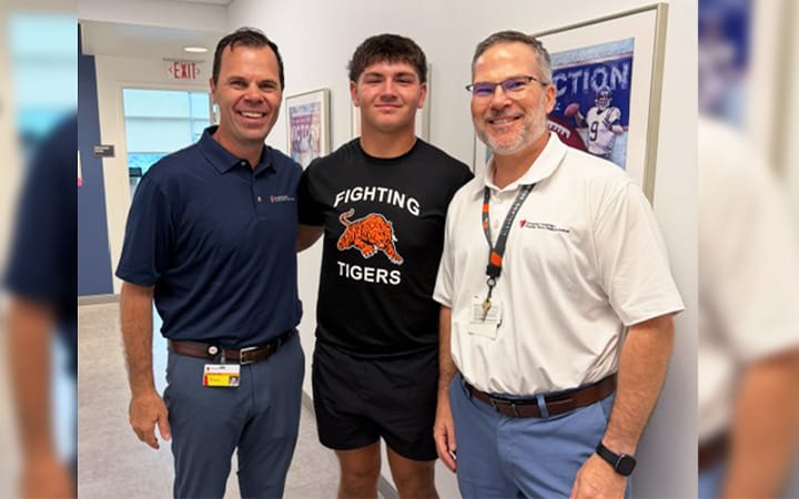 North Baltimore High School quarterback Luke Long poses with James Voos, MD and Adam J. Peiffer OD, MS