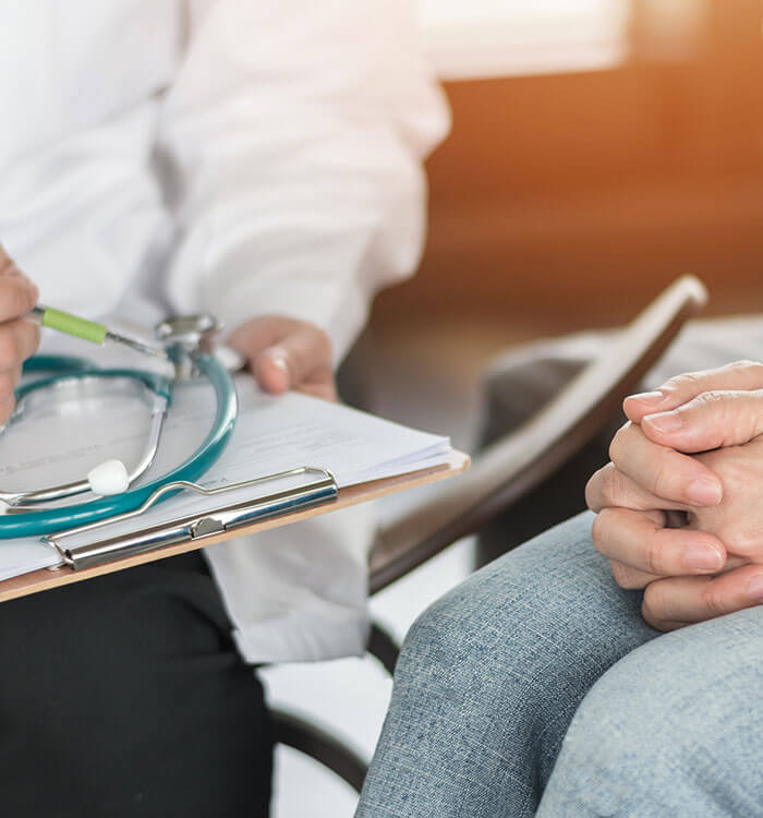 Doctor consulting with female patient only hands showing.