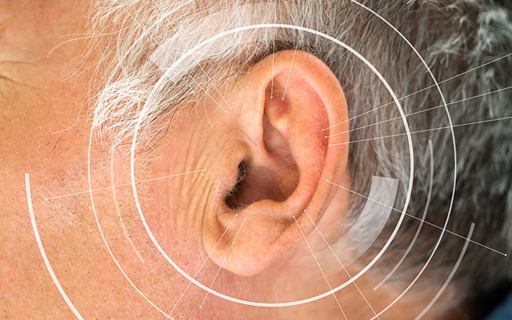 Human ear with sound waves depicting Acquired hearing loss.