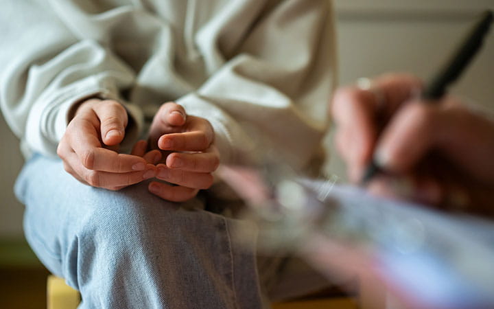 Close-up of therapy session with anxious teenage girl.