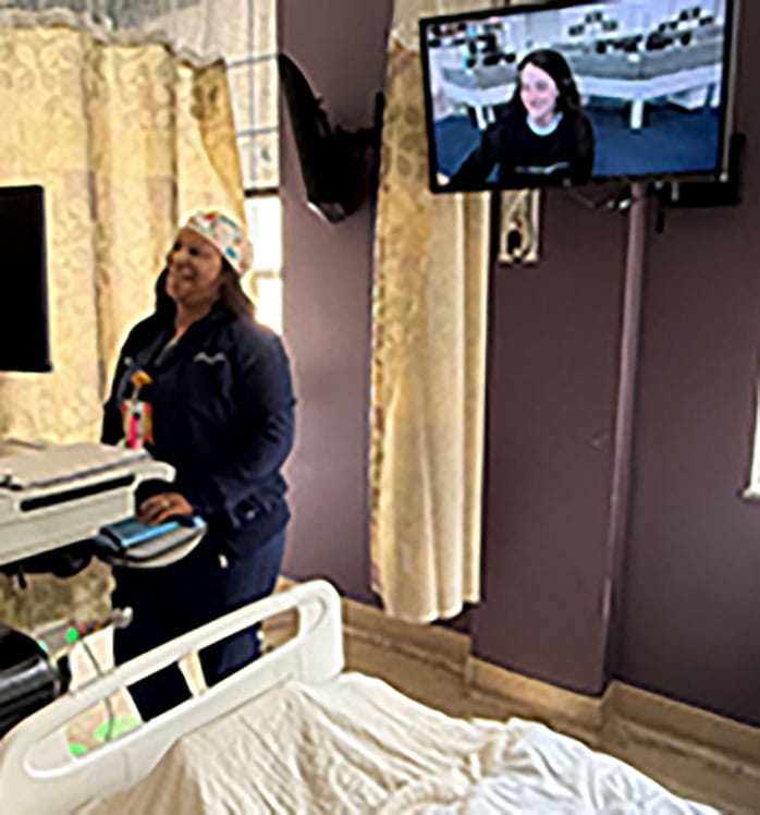 Nurse talking to another nurse on tv showing virtual nursing interaction in a pediatric patient room.