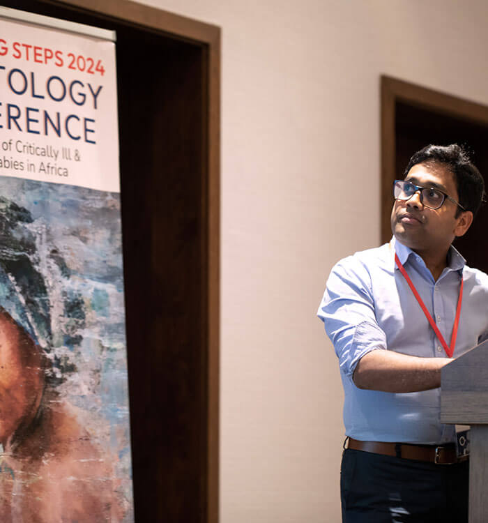 Samudragupta Bora, PhD standing at podium presenting at the Tiny Feet Big Steps conference.
