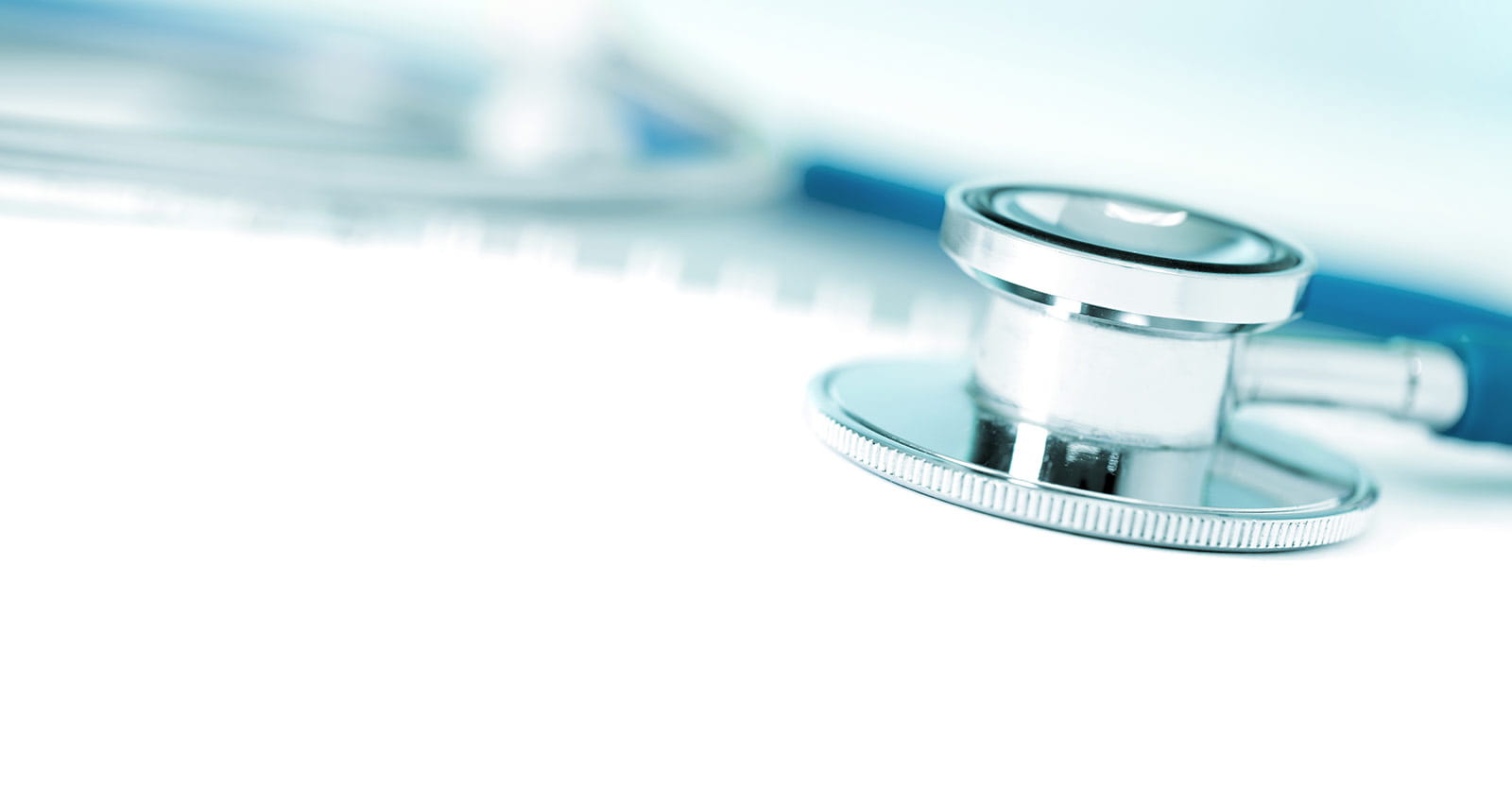 Close-up of a stethoscope with a spiral notebook