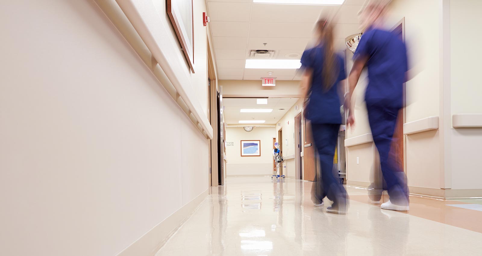 Medical personnel walk down a busy corridor