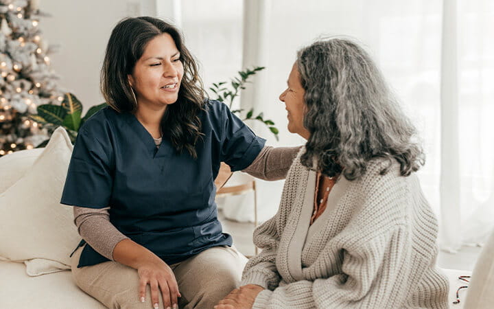 Registered Nurse assisting senior woman in her home