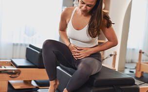 Woman experiencing menstrual discomfort after workout in studio