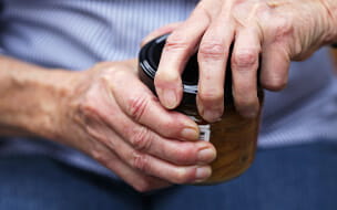 Close-up of a males hands trying to open a jar