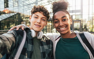 Portrait of two teenagers taking a selfie with a mobile phone